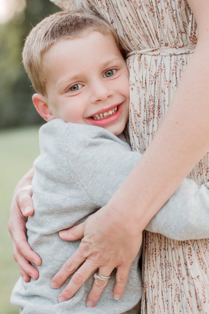 A little boy hugging his mother during adorable family portraits with laurel smith photography, a family portrait photographer serving Detroit Michigan and the surrounding cities professional family pictures neutral outfit ideas for family pics how to have a successful family picture session with young kids detroit family photographer #detroitfamilypictures #detroitfamilyphotographer #familypictures #familyportraits #familypictureoutfits #familyoutfitinspo