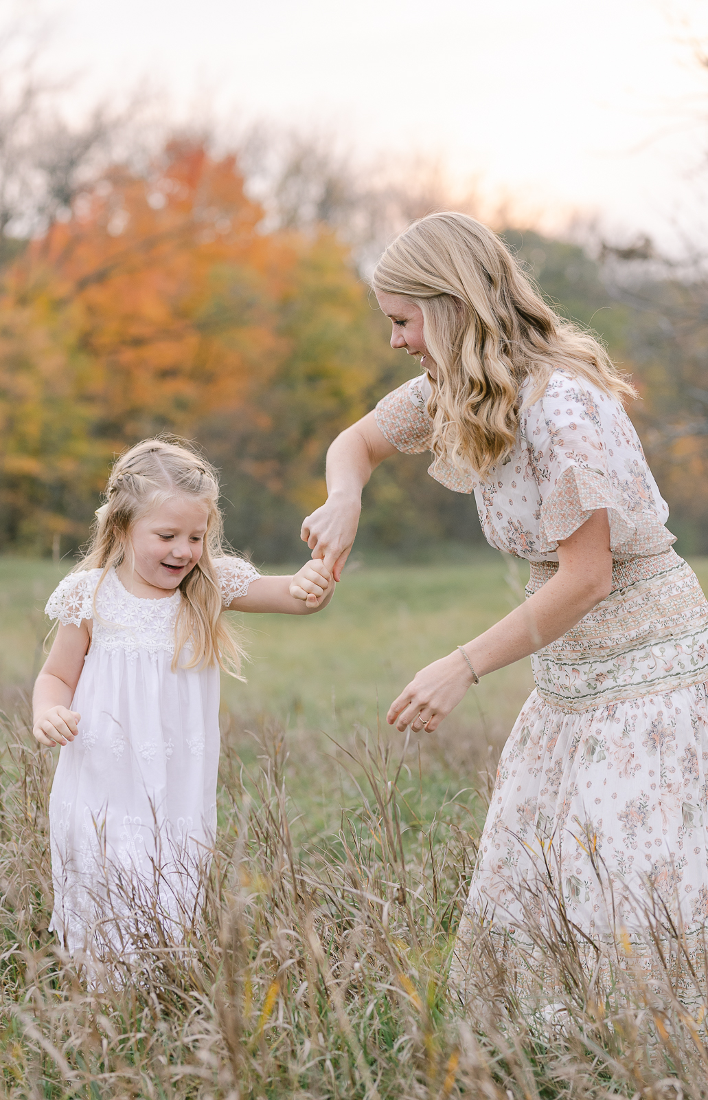 Plymouth, Michigan photography, Laurel Smith Photography captures this playful mother and daughter twirl in a tall grass field. little girl twirling, mom and daughter dancing in field, professional plymouth michigan family photographer, falll michigan family photos, laurel smith photography, white little girl dress, white and ivory floral womens dress #DetroitMichiganFamilyPhotographer #DetroitMichiganPhotographer #FamilyPhotoOutfitInspiration #PlymouthMichiganFamilyPhotographer #PlymouthMichiganPhotographer #ExtendedFamilyPhotos #DetroitMichiganFallFamilyPhotos #LetThemBeLittle #LetTheKids #DetroitMichiganLifestylePhotographer