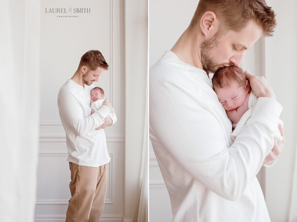 Dad and baby snuggling near window during newborn photo session in Detroit.