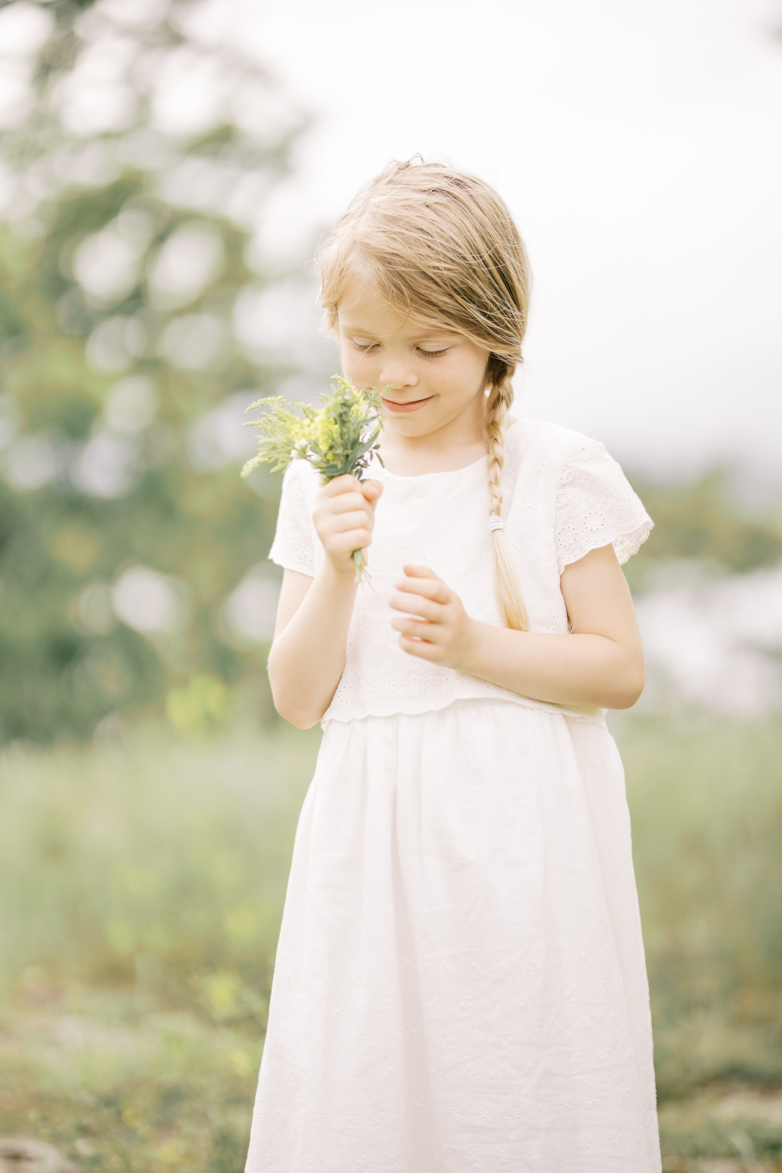 Things to Do in Detroit With Kids blog post by Laurel Smith Photography features a young girl smelling a wildflower bouquet in her hands in the summertime. Detroit photography locations wildflower kid vacation Detroit, Michigan #professionaldetroitphotography #familyfundetroit #laurelsmithphotography #laurelsmithfamilyphotography #detroitfamilyphotographer #thingstodoindetroitwithkids #detroitfamilyactivities #familyphotographerMichigan #DetroitFamilies #LaurelSmithDetroit