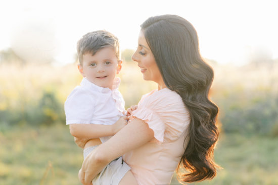 Mother and son in field during sunset golden hour in photo portrait session with Laurel Smith Photography. Shop small this holiday season with this Detroit Small Business Gift Guide.