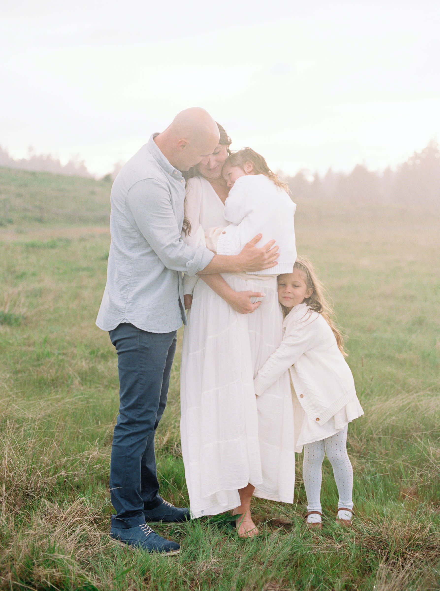 Family hugging each other in a field