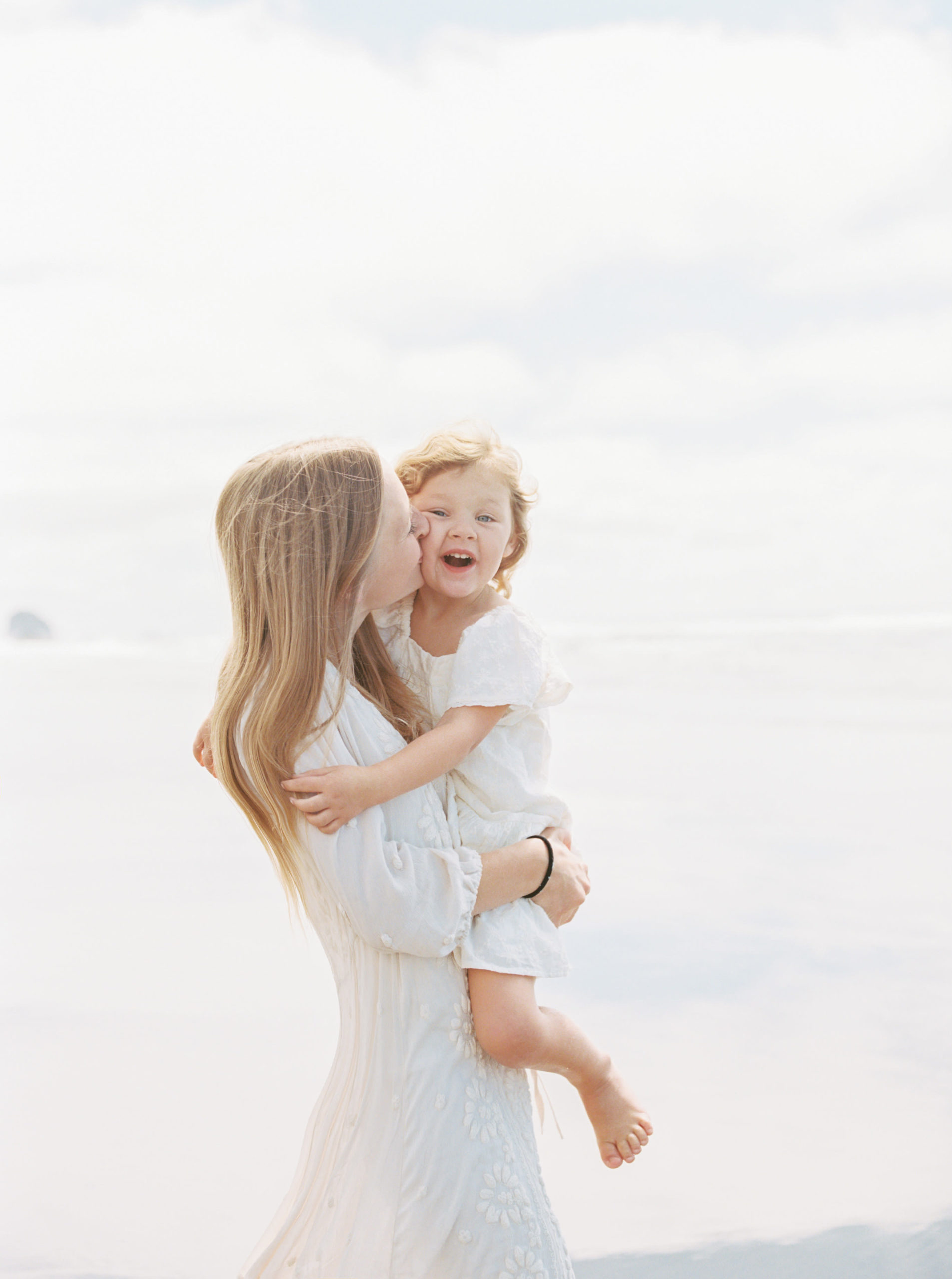 little girl being kissed on the cheek by her mom
