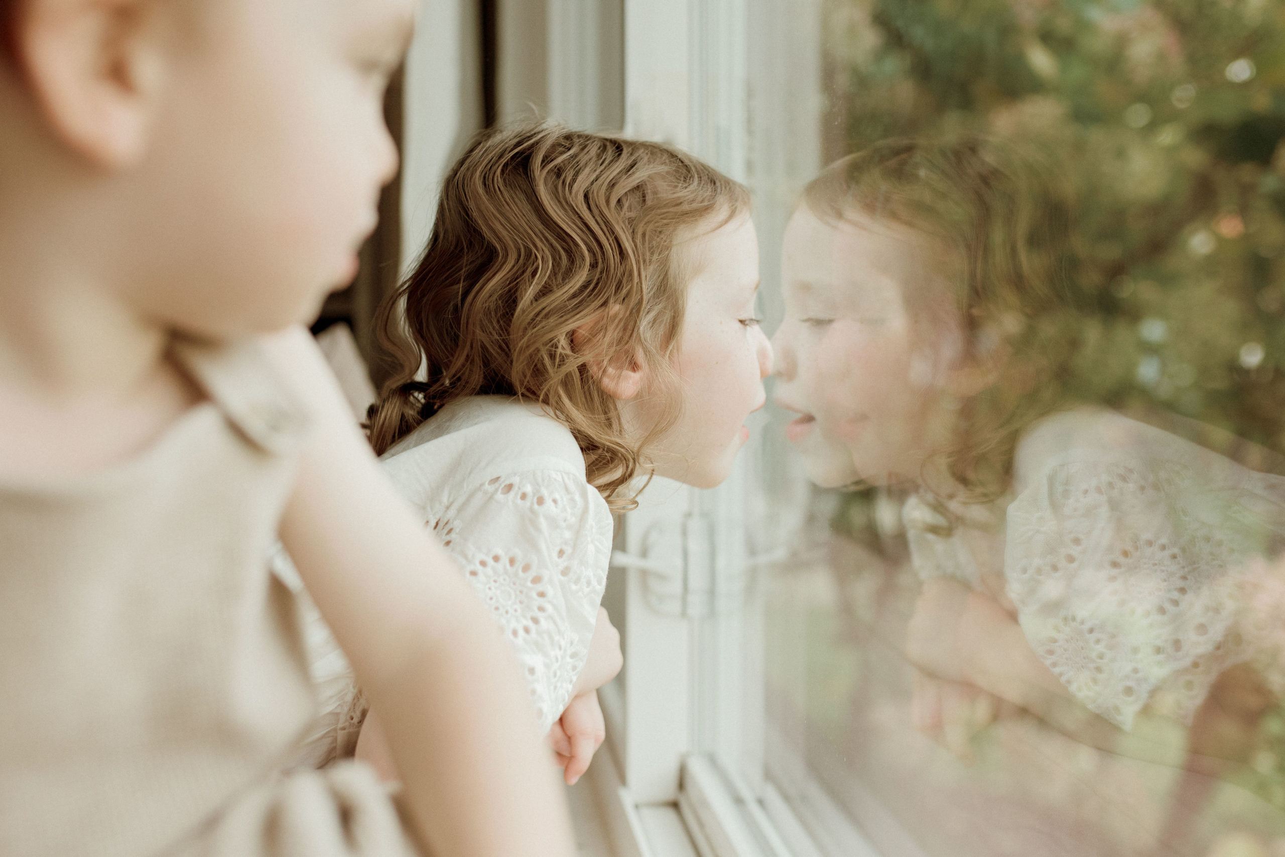 little girl with her nose against the window