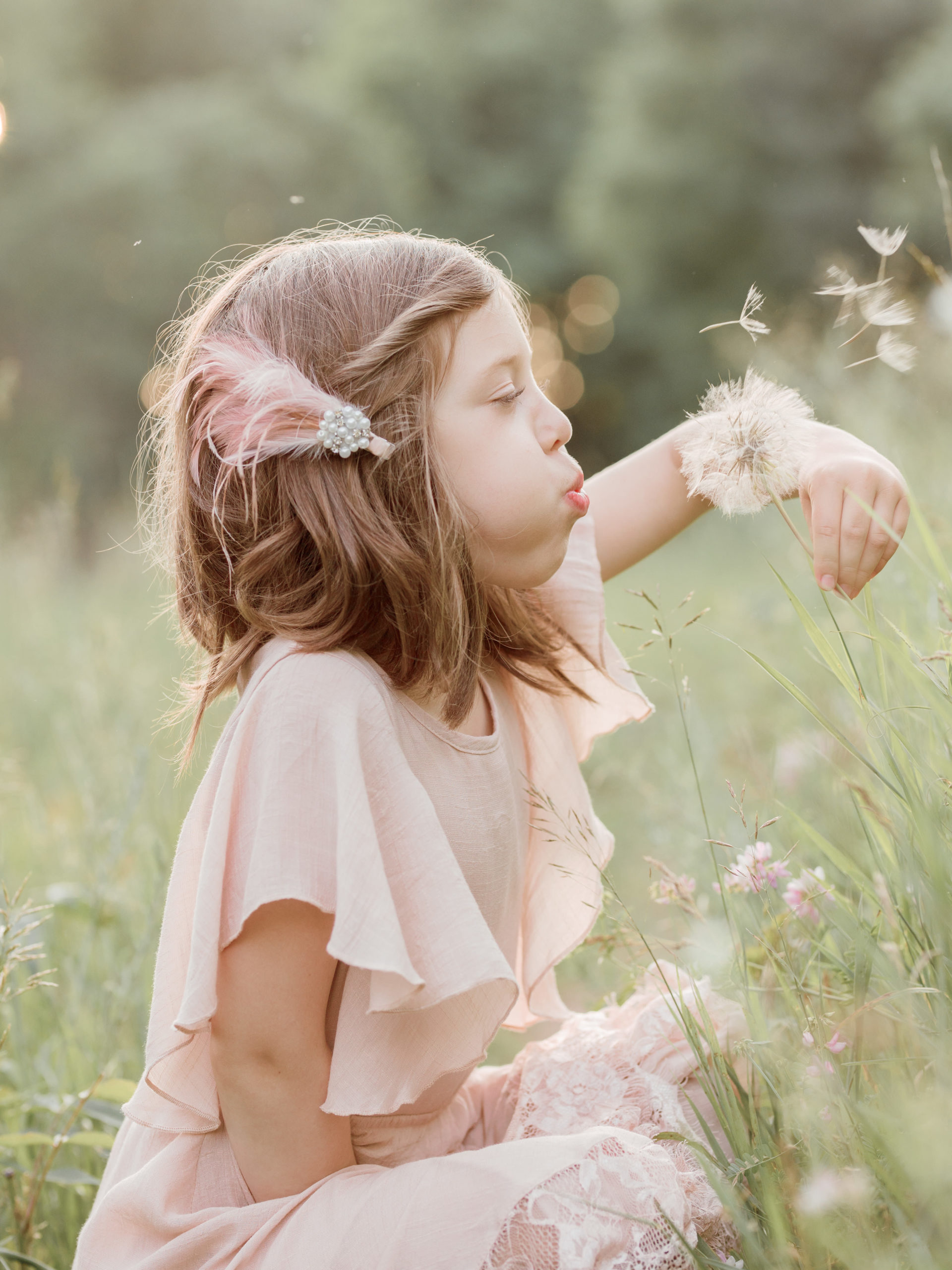 little girl blowing on flowers in a field Santa Cruz Kids