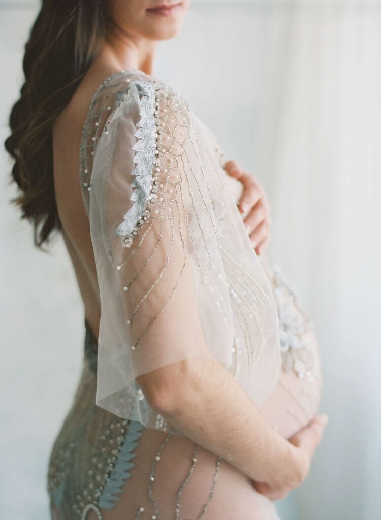 woman wearing a silver beaded dress during maternity photos in san francisco photography studio with laurel smith photography