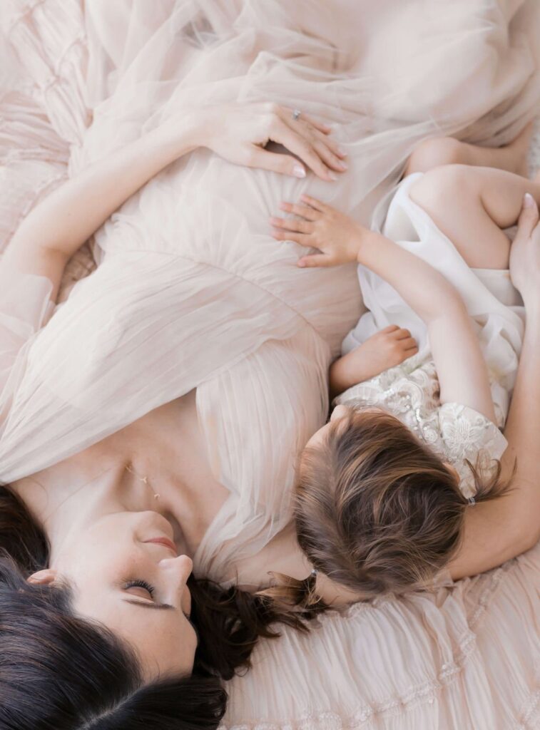 mother and daughter with daughter's hand on mother's pregnancy bump during her maternity photos in san francisco photographed by laurel smith photography