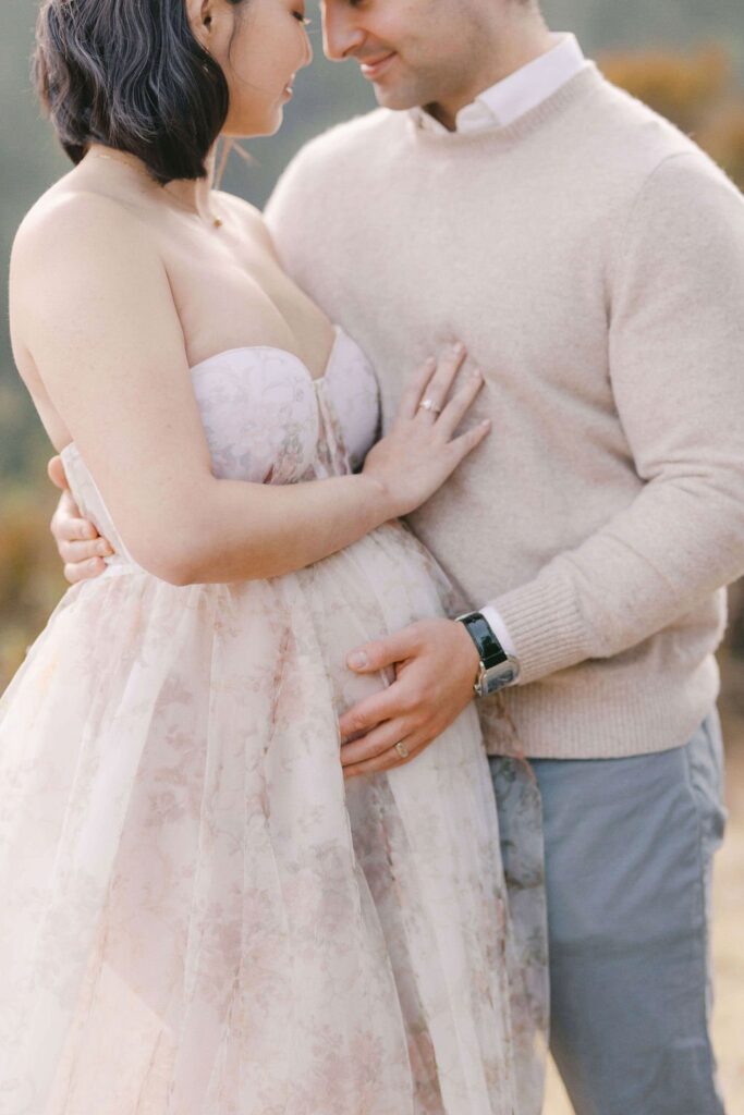 couple lovingly staring at each other with man's hand on woman's pregnancy bump during their ​maternity couples photos san francisco with laurel smith photography