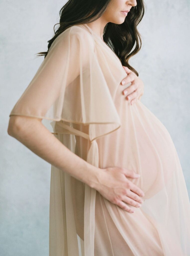 woman in beige see-through flowy dress during her san francisco maternity photos session with laurel smith photography
