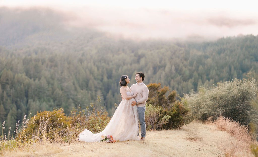 couple on cliff with forest background during their maternity couples photos in san francisco​ with laurel smith photography