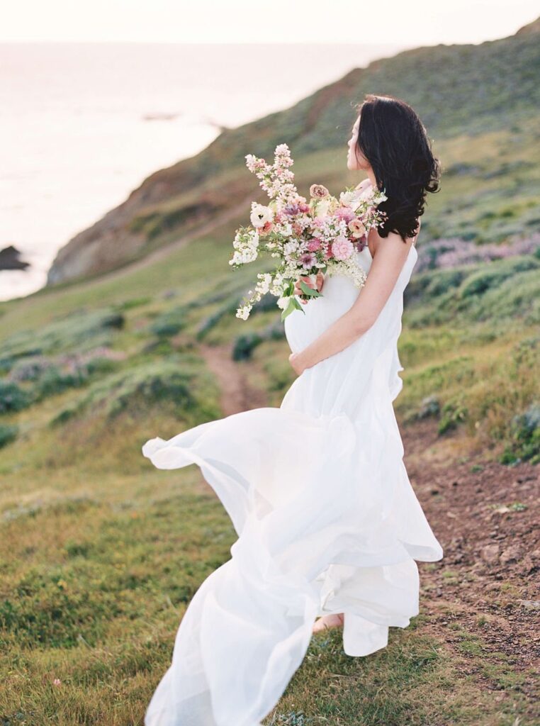 woman with bouquet in hand holding her pregnancy bump during her san francisco maternity photos