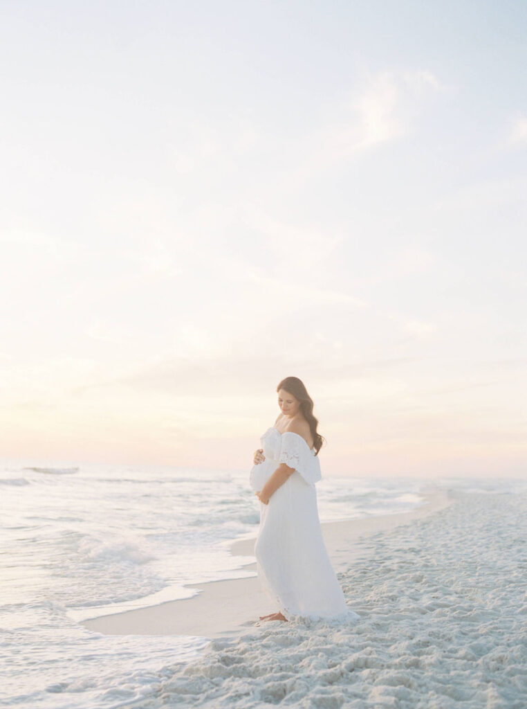 Solo maternity pictures in San Francisco standing at the shoreline  in soft coastal light.