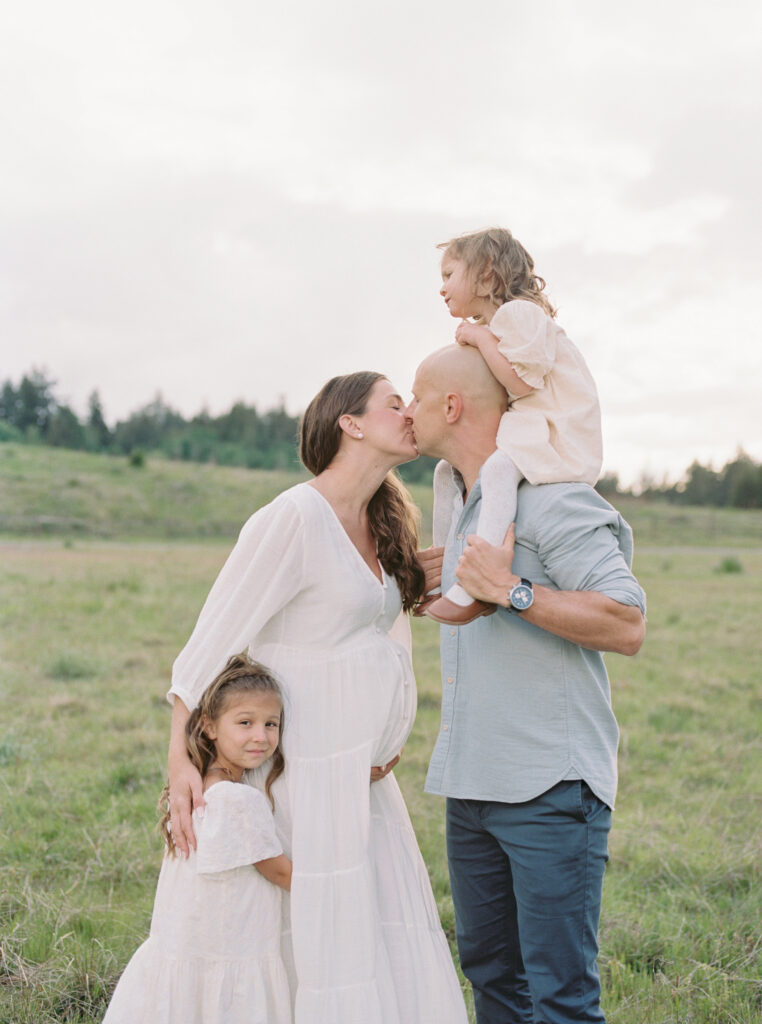 Maternity photography in San Francisco with mother in flowing neutral gown, her partner and her two little girls. 