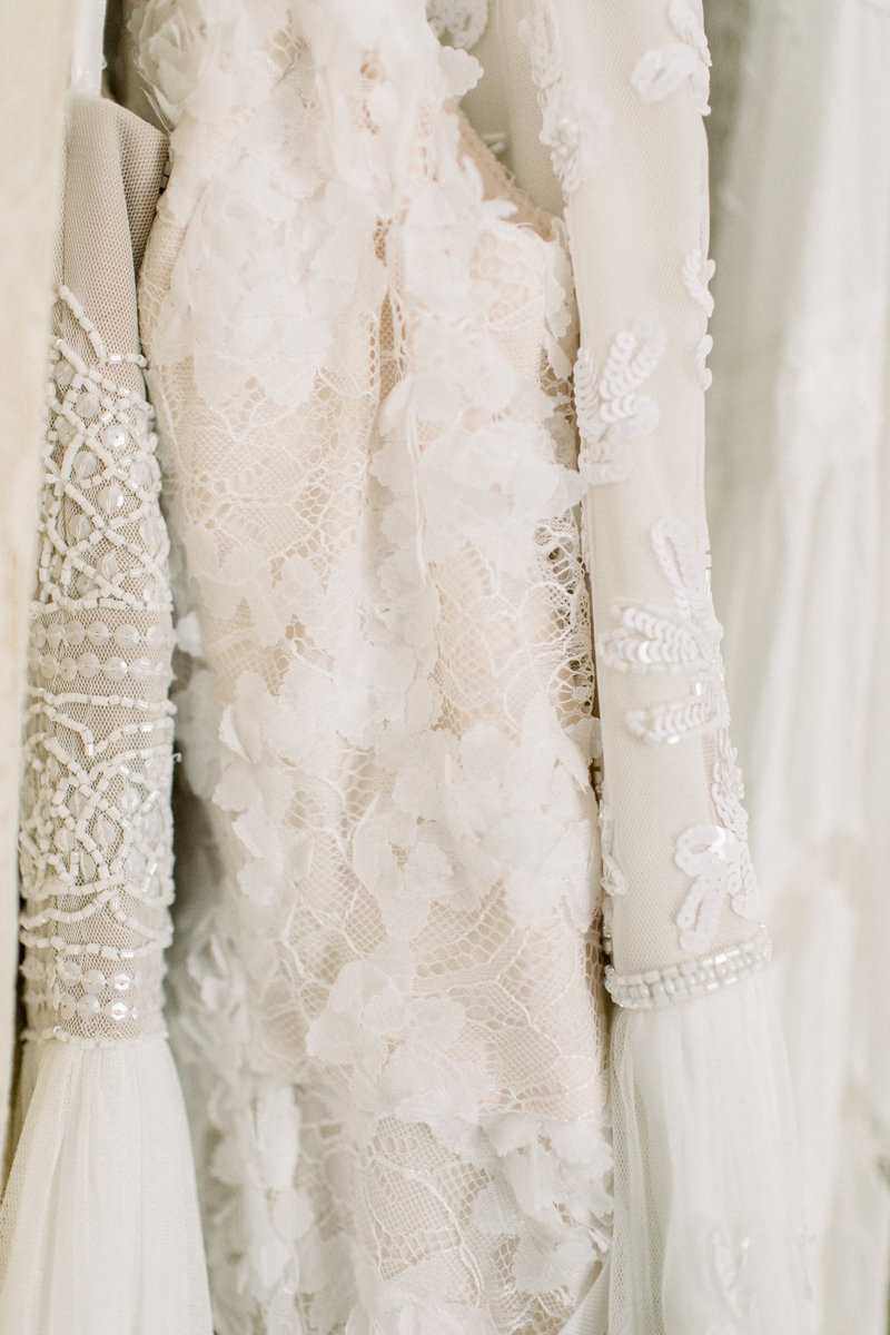 Close-up of delicate cream-colored lace fabric with intricate floral patterns, embroidery, and sheer textured layers, softly lit to highlight fine details often styled in sessions with a bay area professional newborn photographer