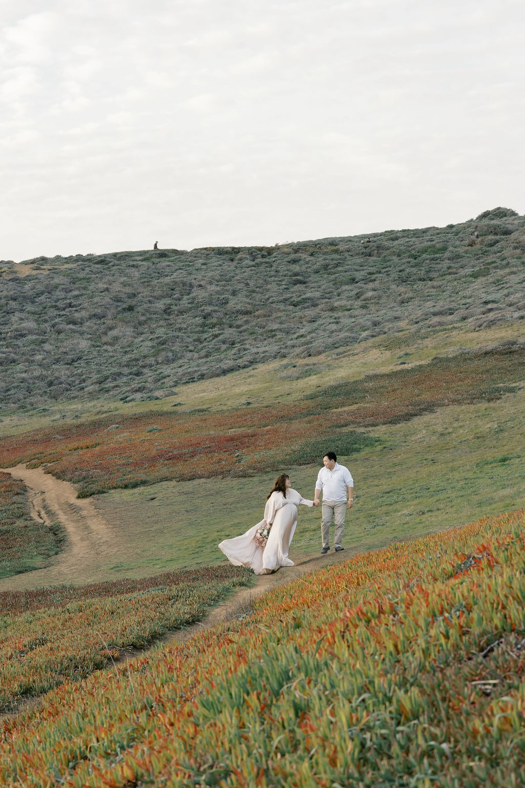 couple during their rodeo beach ca maternity photoshoot at one of the iconic viewpoints near the beach