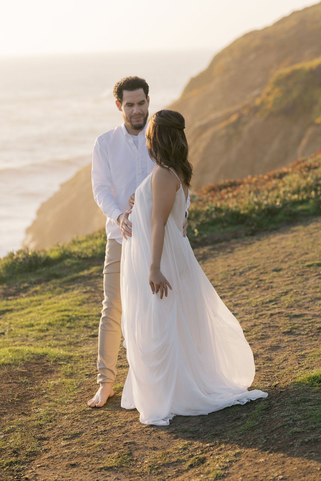 couple lovingly looking at each other during their maternity photoshoot at rodeo beach san francisco ca