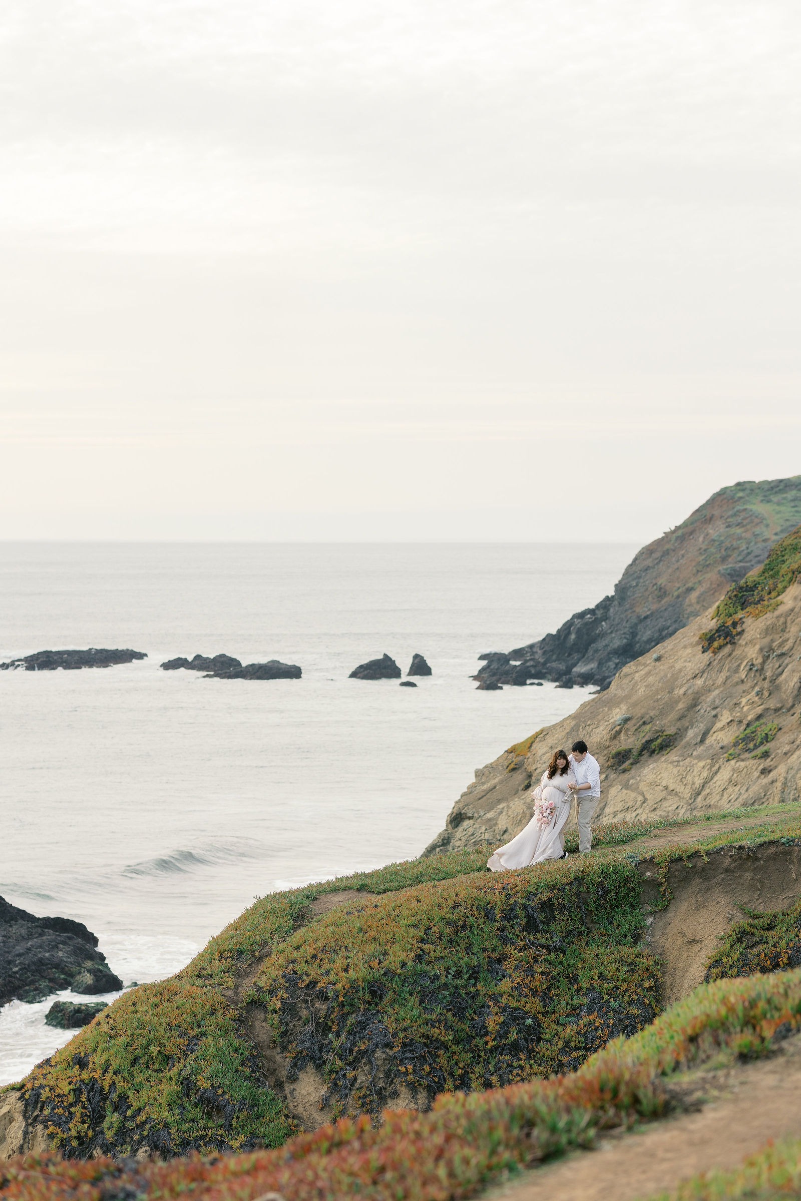couple during their rodeo beach ca maternity photoshoot overlooking the ocean 