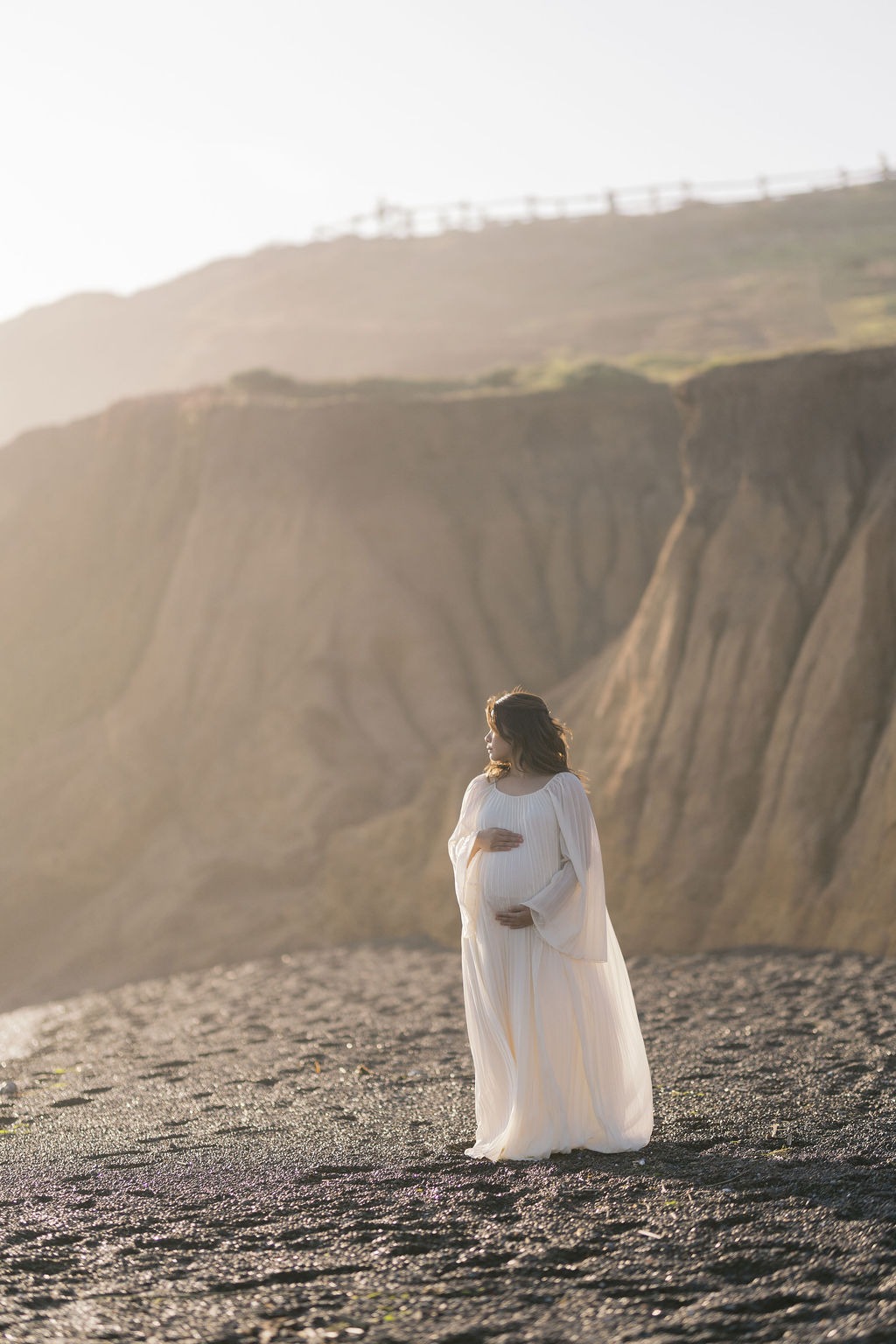 woman during her golden hour maternity photoshoot at rodeo beach ca