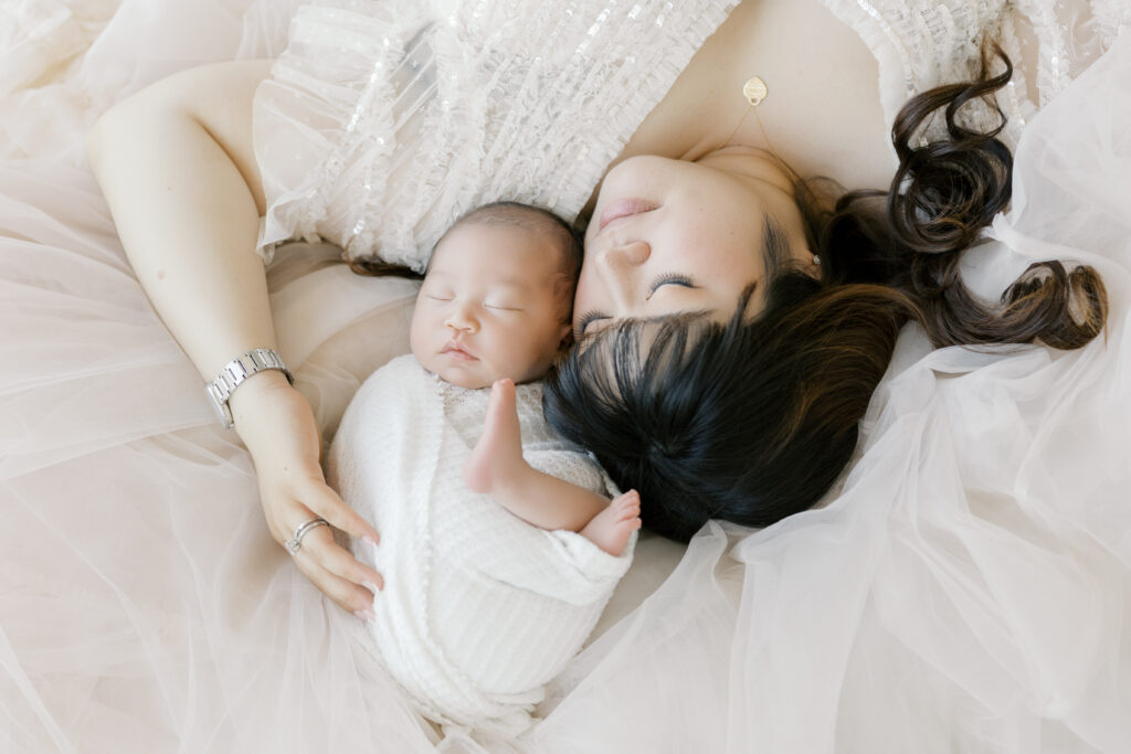 Mother and newborn baby portrait during the best time for newborn photos in a studio session. 