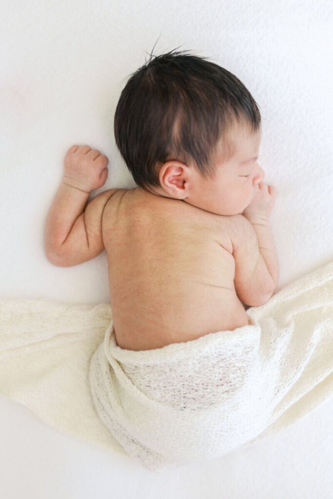 Sleeping newborn baby portrait showing when to book newborn photos during the early newborn stage. 