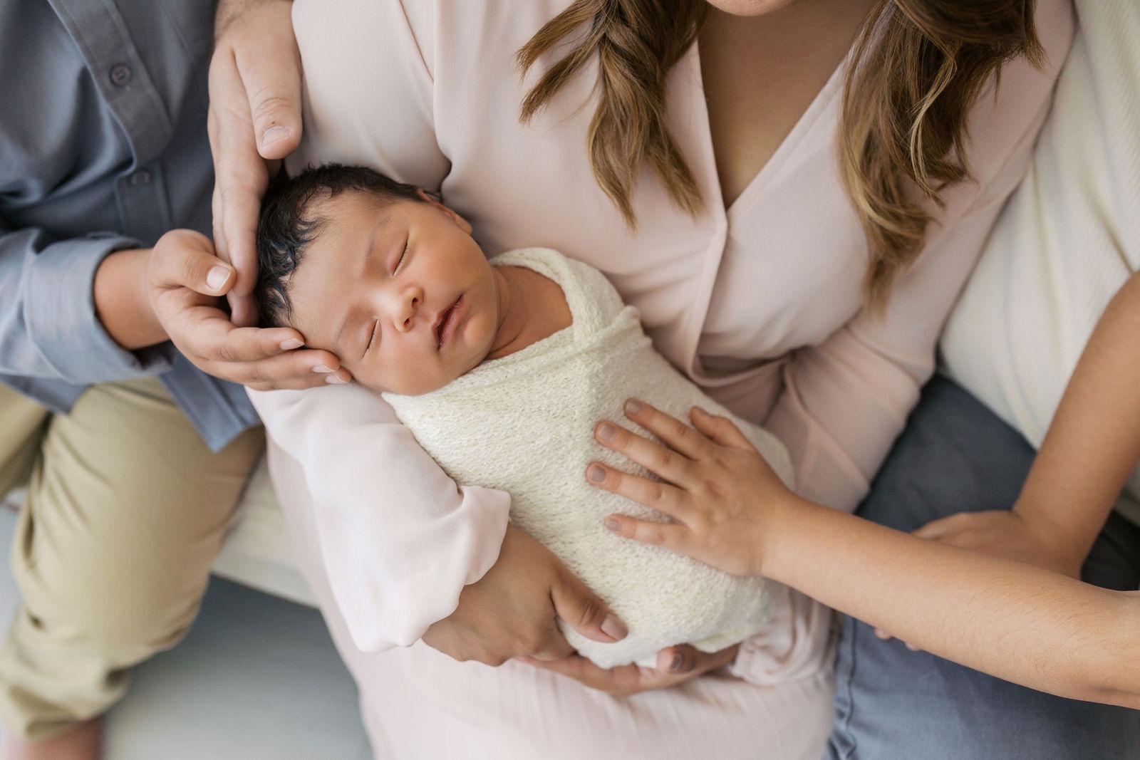 photograph of a newborn being held by their entire family during a family newborn session