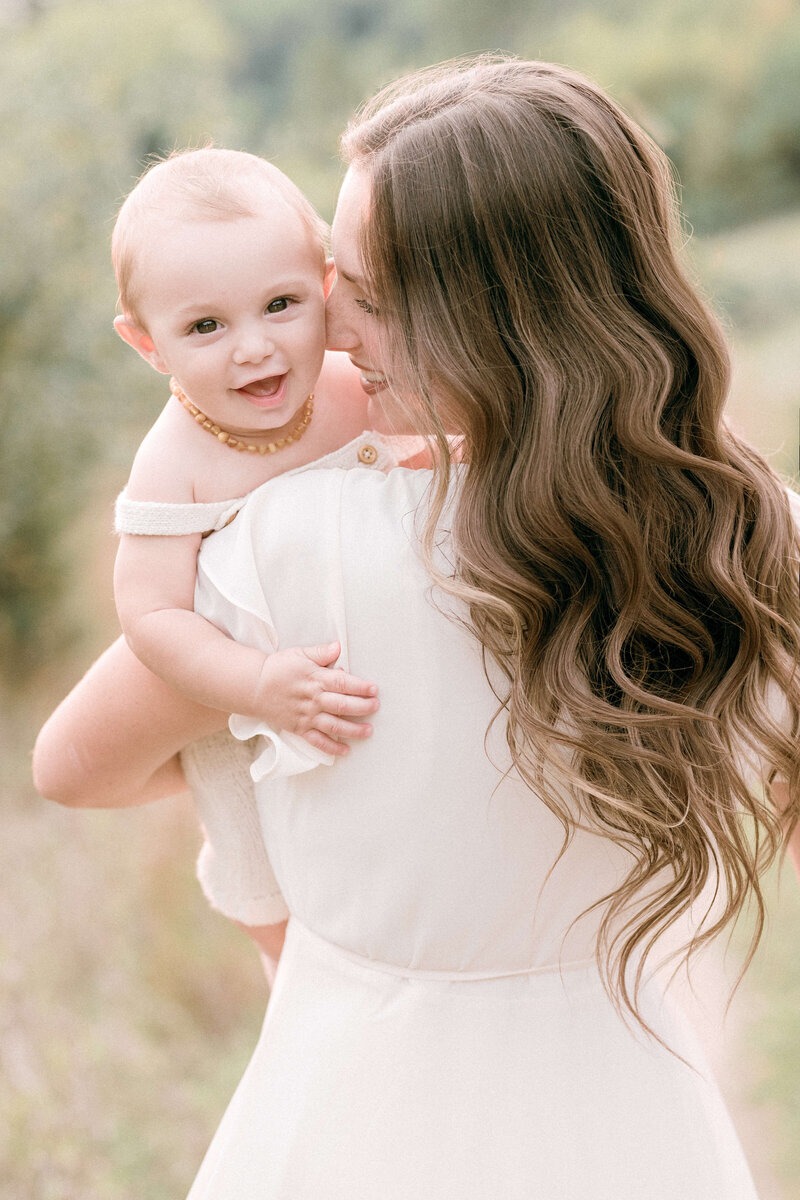 Mother holding her smiling baby during an outdoor family photography session