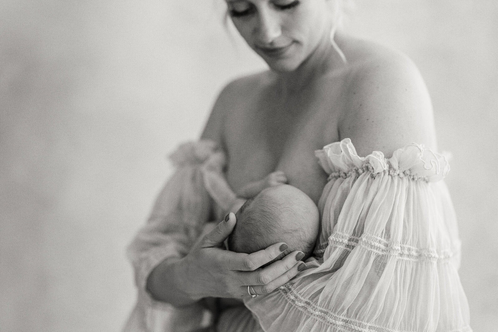 Mother breastfeeding her newborn during a quiet newborn session